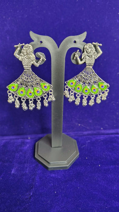 Peacock Flute Player Oxidized Earrings with green mor pankh meenakari on display stand